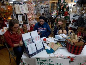 Sycamore High School students took advantage of last week’s Small Business Saturday to offer custom-made holiday cards and gift bags at a table set up inside Sweet Earth on State St. (Photo by Jack McCarthy / Chronicle Media)
