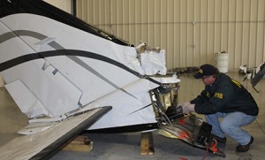 NTSB air safety investigator Todd Fox examines the tail section of the Cessna 414A that crashed early Tuesday morning in Bloomington, Ill.   