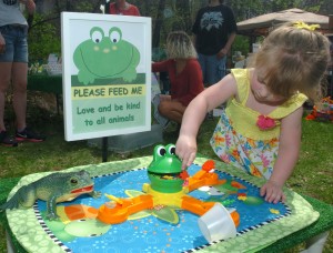 Two-year-old Emma Heinz plays a game in the “Farmed Animal Sanctuary” area of Forest Park Nature Center’s 11th annual Earth Day Festival Saturday in Peoria Heights. The area provided fun activities for kids while promoting vegan choices that protect animals.  Photo by Elise Zwicky.