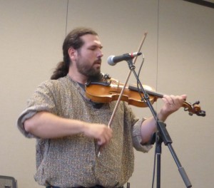 Dennis Stroughmatt explained the history of the French in Illinois through the use of music at the Fondulac Library on June 17. Chronicle Media photo.
