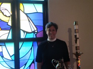 Sherer stands next to one of the church's stained glass windows.