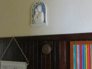 A boxing bell, left from when there was a gym at the church, is located under a plaque honoring Mary, the mother of Jesus.
