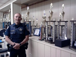 Lt. Joe Gliniewicz poses next to the trophy shelf, filled with honors obtained and earned by the Fox Lake Explorers Post 300, during its many national and state competitions. 42 of them were won at Tactical competitions in Chandler, Ariz. against much larger metro and sheriff's office troops, with larger resources. Fox Lake is entirely self-funded through donations and parking details. (Photo by Gregory Harutunian/for Chronicle Media)