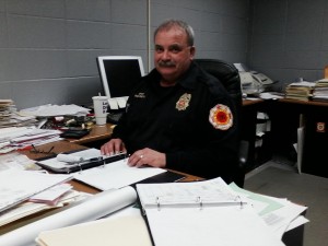 Rod Smith, the Elkhorn Area Fire District's chief, and MABAS division president, seated behind his desk looking over the MABAS call book listing each fire company and their resources within the Division 103 Walworth county jurisdiction.
