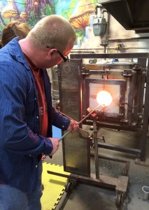 Chuck Caudill of Pekin slides glass into a reheating chamber at JDraper Studios while learning the art of blowing glass at a private date night workshop with his wife, Meredith, under the tutelage of studio owner Jeremie Draper.