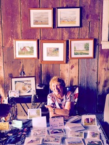 Joan McEachern, vice president of the Kendall Arts Guild , with some of her work at a show at the Dick-Murst Farm this past summer. (Photo courtesy Kendall Arts Guild)