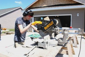 Pekin HIgh School student Noah Waters works on the siding at a student-built home. Pekin is among the high schools in Illinois that allow students to get hands-on experience in the building trades by constructing a house. (Photo courtesy of Pekin HIgh School)