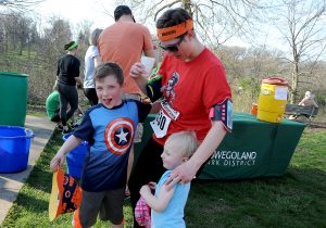 Kimberly Mayer of Plainfield gets hugs from her kids; 6-year-old Paul and 3-year-old Emily, after finishing the race during the Saw Wee Kee Spring Trail Challenge at Saw Wee Kee Park in Oswego on Saturday, April 16, 2016. Photo by Steven Buyansky