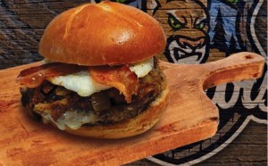 “The Fatty” is half-pound hamburger patty topped with fried egg, jalapeno bacon, Monterey jack cheese, pulled pork, brisket and grilled onions. (Photo courtesy Kane County Cougars)
