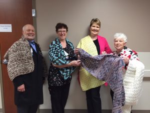  The Eureka United Methodist Church and the Eureka Greater Area Kiwanis Club have joined together on a project to furnish prayer shawls to be given to hospital patients.  These shawls will each be blessed with a special prayer and then donated to the hospital. Pictured (left to right) are Advocate Eureka Hospital Staff Chaplain Jim Turner, Linda Vierhout, R.N., and Vickie Hinthorne Unit Secretary receiving shawls from Nancy Aldridge representing the Eureka United Methodist Church and the Eureka Greater Area Kiwanis Club.(Photo courtesy Nancy Aldridge)
