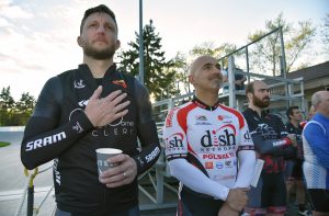 Jeff Whiteman of Chicago (left) and Aram Bayzaee of Northbrook listen to the National Anthem, performed in the stands by trumpet player David Maller of Glenview. 