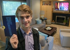 Holding up the secret reveal card bearing his name, Ryan Goldsher, 19, of Northbrook and a 2015 Glenbrook North High School graduate, at his home in Northbrook May 18, 2016. Goldsher won $10,000 for his celebrity impressions on the USA Network show “First Impressions,” a competition show featuring comedian Dana Carvey.