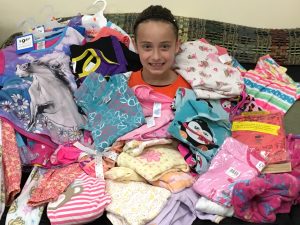 Karrigan Latham with the pajamas she collected at her birthday party for the Thread, Hope & Love in Washington. 