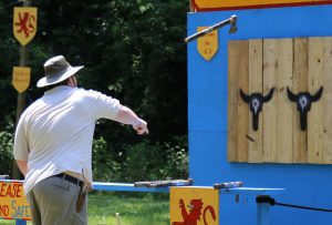 A guest at last year’s Olde English Faire at Wildlife Prairie Park plays an axe-throwing game. The fair will feature other games as well, including archery. It’s the only medieval festival offered this summer in central Illinois. (Photo courtesy of Wildlife Prairie Park)