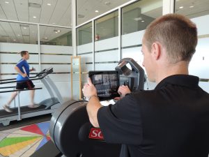 Jonathan Gallas, a physical therapist at OrthoIllinois uses an iPad to take a video of Matt Denning, a RunRight client.