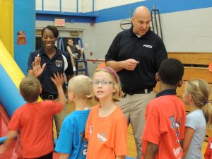 RPD Officers Courtney Tillmon & Jeff Oberts   supervise kids in the bounce house at the RPD's summer Safety Camp. (Photo by Lynne Conner/for Chronicle Media)