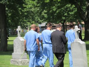 Students from the Worsham College of Mortuary Science in Wheeling carry flowers to the grave sites of indigent and unclaimed individuals. (Photo by Kevin Beese/for Chronicle Media)