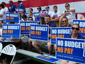 Supporters of Comptroller Leslie Munger hold "No Budget, No Pay" signs at the Illinois State Fair. (INN Photo by Greg Bishop)
