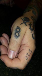 Of the 55 tattoos Oswego resident and tattoo artist Chris Baker has, it's a small semicolon etched on his left thumb that most people ask about. Baker said he got the tattoo to raise awareness about suicide after the death of his friend Scott. (Photo by By Erika Wurst for Chronicle Media) 