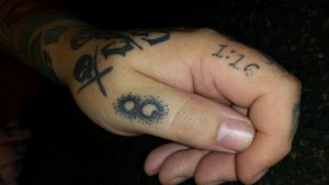 Of the 55 tattoos Oswego resident and tattoo artist Chris Baker has, it's a small semicolon etched on his left thumb that most people ask about. Baker said he got the tattoo to raise awareness about suicide after the death of his friend Scott. (Photo by By Erika Wurst for Chronicle Media) 