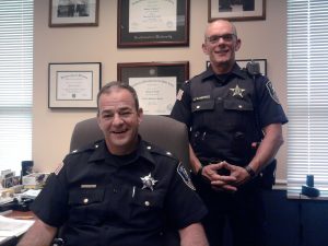 Former Fox Lake police chief Michael Behan and Lt. Charles Gliniewicz (standing) in a 2014 photo, taken at the municipality's police station. 