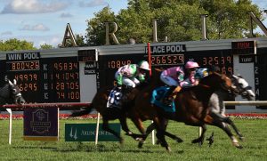 The scoreboard is the focus as Jockey Daniel Tudhope crosses the finish line as the first place finisher of the Arlington Million with his horse Mondialiste at Arlington International racecourse in Arlington Heights on Aug. 13, 2016. (Photo by Karie Angell Luc/ for Chronicle Media)