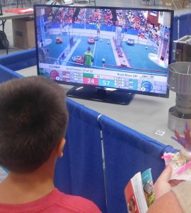 A young visitor watches action on a nearby monitor during the Rock River Off-Season robotics competition on July 30. 