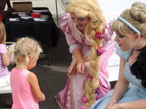Marley Spain meets Rapunzel and Cinderella from Once Upon a Dream Performances at Rockford City Market. (Photo by Lynne Conner/for Chronicle Media)