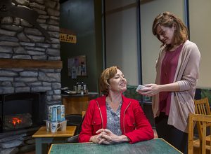 Abby Pierce (right) as Anne gets Laura T. Fischer as Candice, blinded from an injury, to repeat her Caribou Coffee order for possible use in her podcast in a scene from "Naperville," playing through Nov. 6 at TheaterWit in Chicago. (Photo by Charles Osgood)