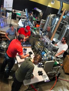 Peoria Brewery staff process craft beer to be served in the brewery's taproom. A feature this year is a single batch brewed using Crystal hops, grown locally at Hallowed Hops Farm in Lewistown, Illinois. 