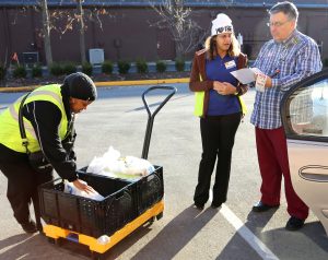 Kroger employees load groceries into a customer’s car as part of its new ClickList online shopping service. Customers arriving for a scheduled pickup, use designated parking spaces and pay when they pick up their groceries. (Photo courtesy of Kroger)     