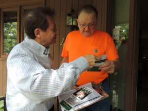 Winnebago County Board write-in candidate Kevin McCarthy stops to  introduce himself and hand a campaign  brochure to District 11 resident Rod Schwandt. (Photo by Lynne Conner/for Chronicle Media)