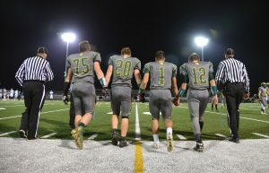 All four jersey numbers add up to 108. From left to right, at the Oct. 28, 2016 Glenbrook North High School varsity football game versus Simeon at Lutz Stadium in Northbrook, the four senior captions of the GBN team enter the field with referees and from left, Bob Pieper, head varsity football coach, for the coin toss. From left, are (No. 75), Joe Jancaus, (No. 20), Gerry Luc, (No. 1) James Mercouris and (No. 12) Kevin Burnside. 