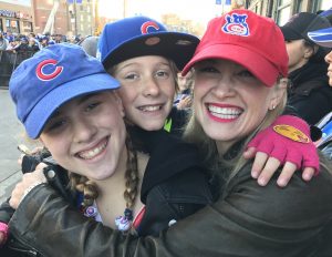 Standing outside of Wrigley Field waiting to catch a glimpse of the Cubs players are (from left) Minnie Dennis, 12, a Chicago seventh-grader, and her brother Ethan Dennis, 10, a fifth-grader and their mother Melissa Dennis. "We just couldn't miss being a part of Chicago sports history." (Photo by Karie Angell Luc/for Chronicle Media)