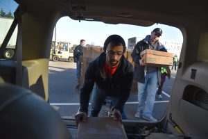 Pastor Charles Amoh (left), assisting Rogers Park-based Family Empowerment Center, loads frozen chicken into a van on Nov. 12, 2016 at the UL headquarters in Northbrook for Community Outreach Day by Hunger Resource Network of Northbrook. On right is John Martinez of Family Empowerment Center of Rogers Park. (By Karie Angell Luc/for Chronicle Media)