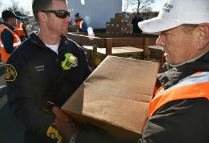 Lieutenant Steve Morris (left) of the Northbrook Fire Department passes frozen chicken boxes to John Golab of Barrington on Nov. 12, 2016 at the UL headquarters in Northbrook for Community Outreach Day by Hunger Resource Network of Northbrook. (By Karie Angell Luc/for Chronicle Media)