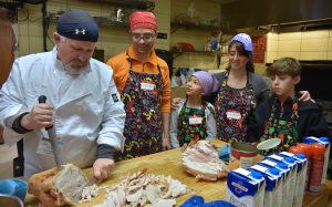 From left, Zach Selch of Evanston, chef/site supervisor, carves turkey with Luis Zapp of Deerfield, his daughter Nicole Zapp, 9, wife Liliana Zapp and son Tomas Zapp, 12, on Nov. 23, 2016 at the Thanksgiving-themed soup kitchen at Beth Emet The Free Synagogue in Evanston, 1224 Dempster St. (Photo by Karie Angell Luc/for Chronicle Media) 