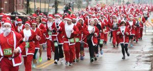 Participants in last year’s Santa Cause 5K race through the Warehouse District. Sponsored by the Peoria Area Convention and Visitors Bureau, this year’s race on Dec. 10 will benefit the Dream Center Peoria. (Photo courtesy Peoria Area Convention and Visitors Bureau)  