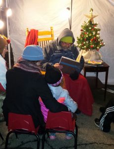 Children huddled together for story time Friday evening, Dec. 2 while taking a break from the bustle of Oswego's Annual Christmas Walk held downtown. (Photo by Erika Wurst/for Chronicle Media) 