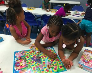A group of children play a board game during an after-school program at Neighborhood House on Peoria’s south side. The two-year-old program offers kids a safe haven to get a good meal, find help with school work and learn life skills. (Photo courtesy Neighborhood House)